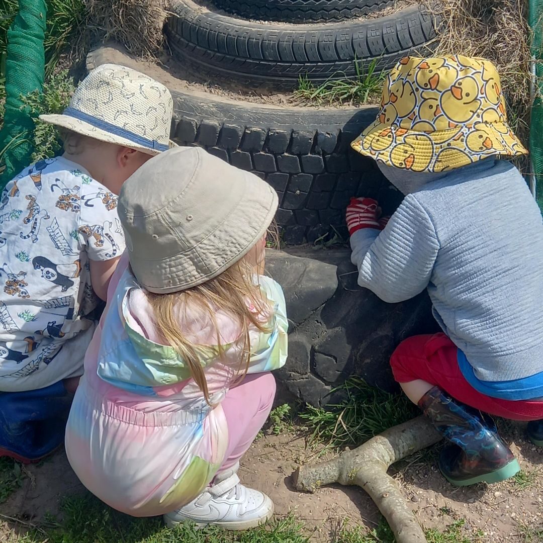 Children exploring sand and containers outdoors