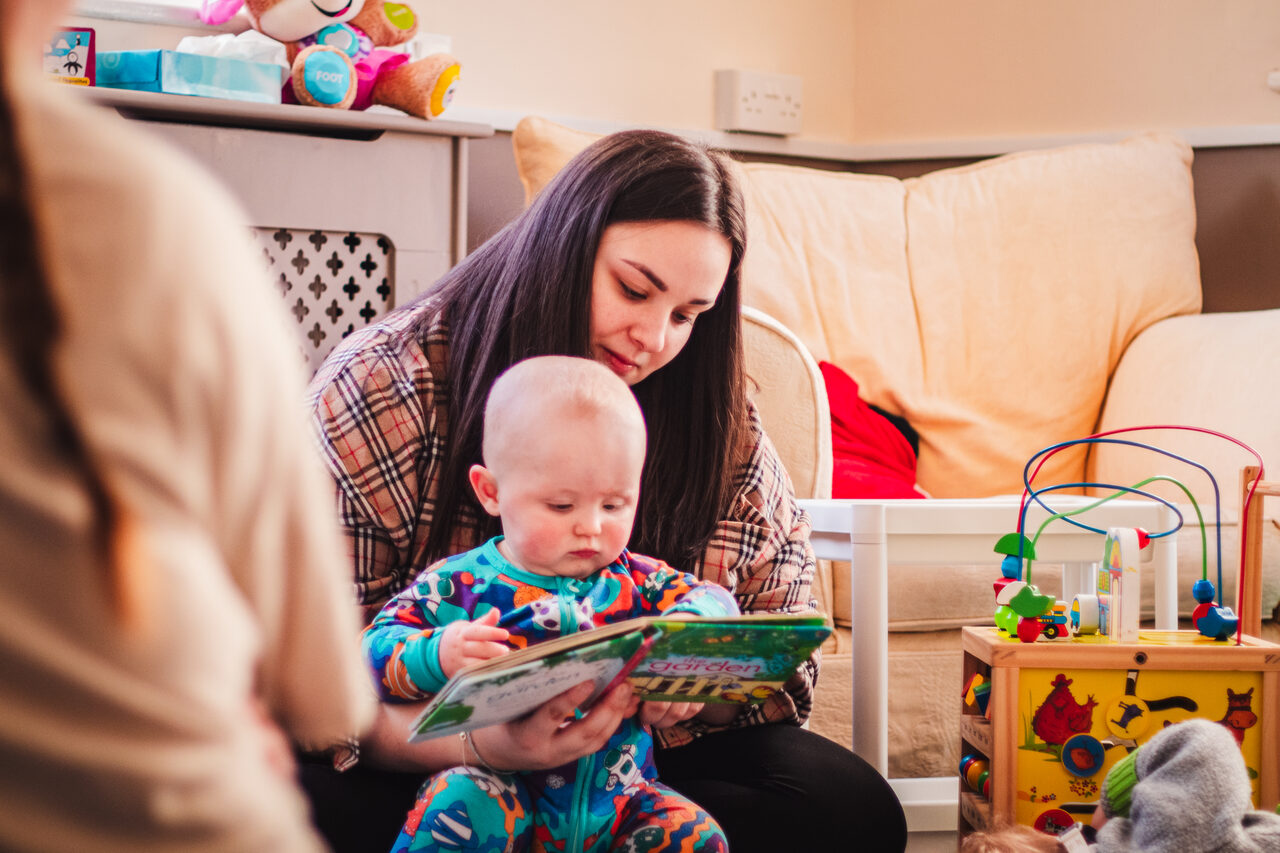 An adult sharing a story with a baby