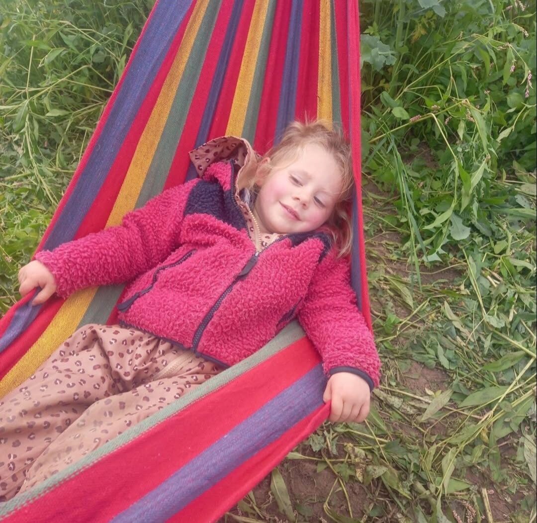 A child relaxing in a striped hammock