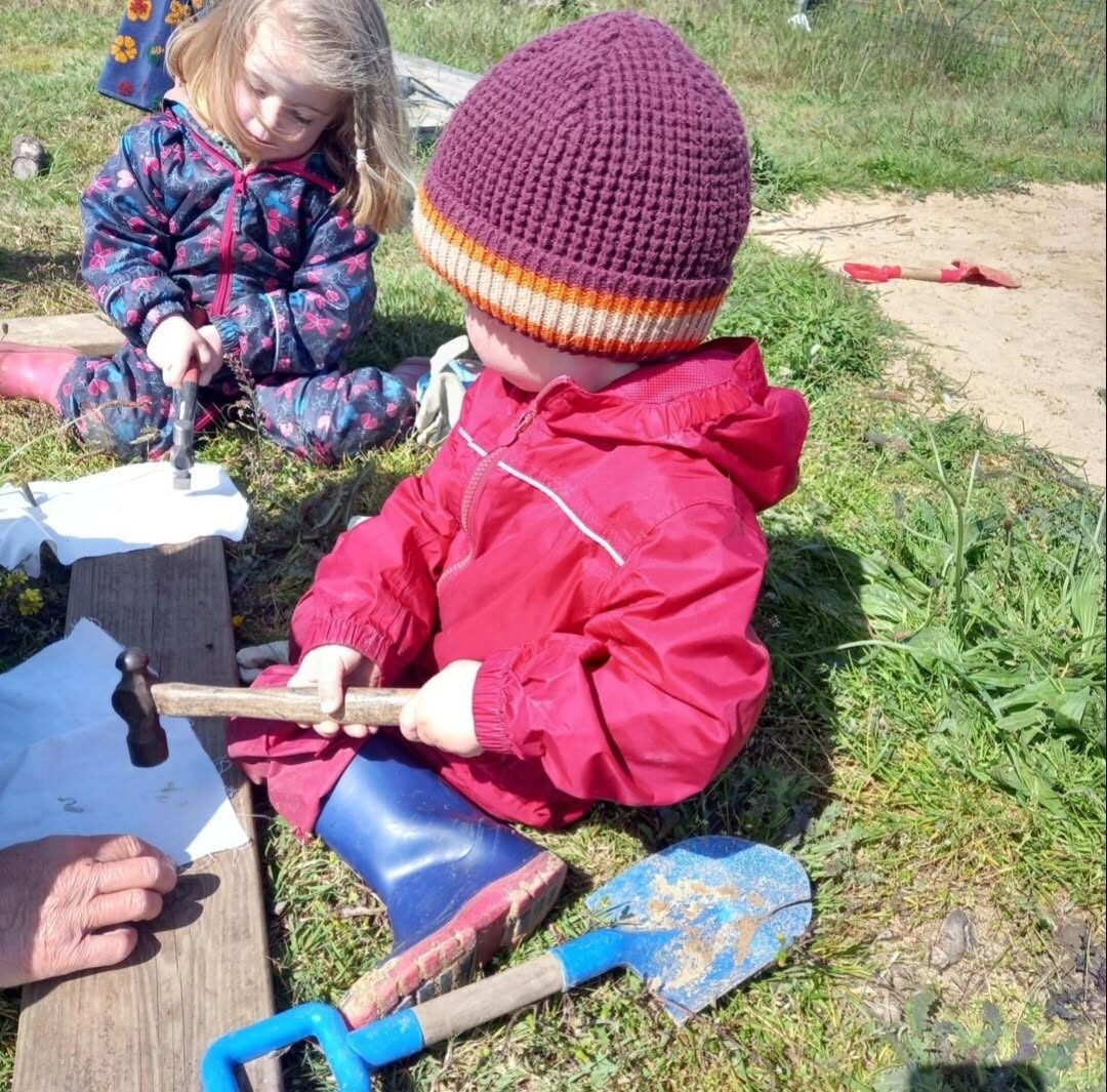 A child busy at an outdoor workbench